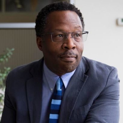 Headshot of Stephan - Black man with glasses and suit